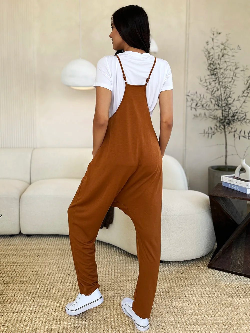 Women's sleeveless V-neck jumpsuit with wide legs and pockets, stylish and comfortable women's apparel by Trendsi.