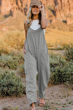 Women's sleeveless V-neck jumpsuit with pockets, lightweight casual romper by Plush Fashion Hub, shown in a full-length view.