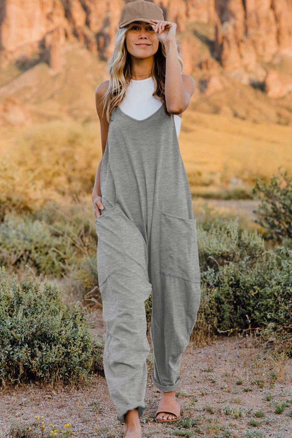 Women's sleeveless V-neck jumpsuit with pockets, lightweight casual romper by Plush Fashion Hub, shown in a full-length view.