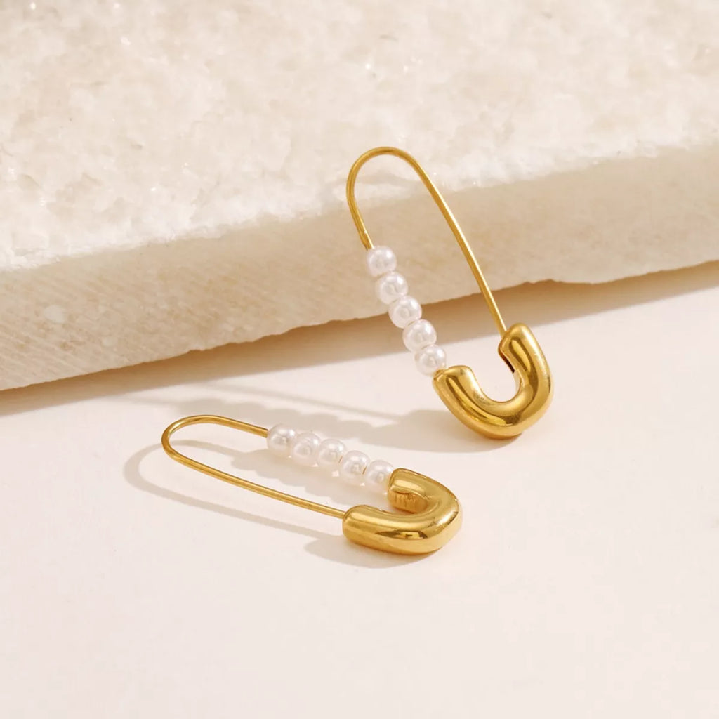 Shopimist safety pin earrings with pearl accents, featuring modern jewelry design and elegant pearl details.