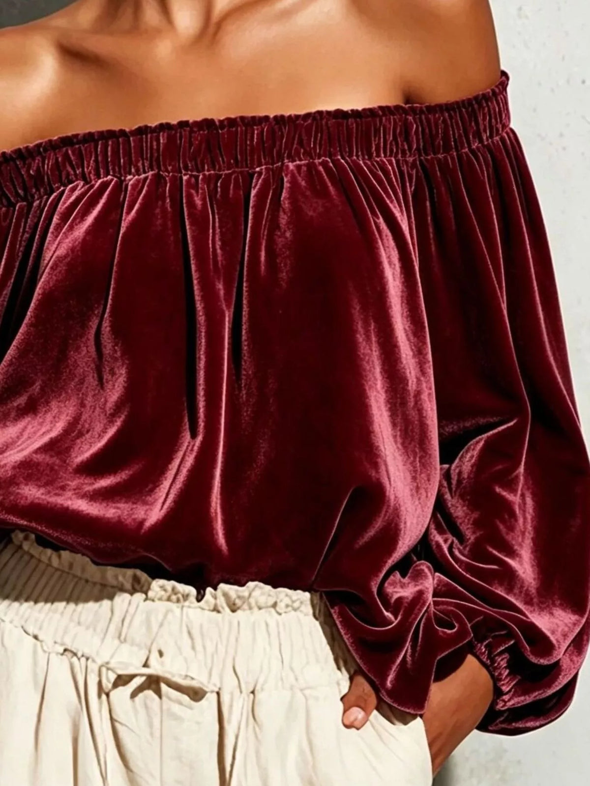 Off-shoulder velvet long sleeve T-shirt from Trendsi, featuring a stylish off-the-shoulder design and soft fabric.