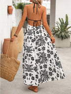 Women's printed halter neck maxi dress with tie-back detail from Plush Fashion Hub, featuring a flowing design and vibrant pattern.