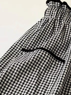 Women's high-waisted gingham wide-leg pants with pockets, stylish trendy pants from Trendsi, shown in black and white checkered pattern.
