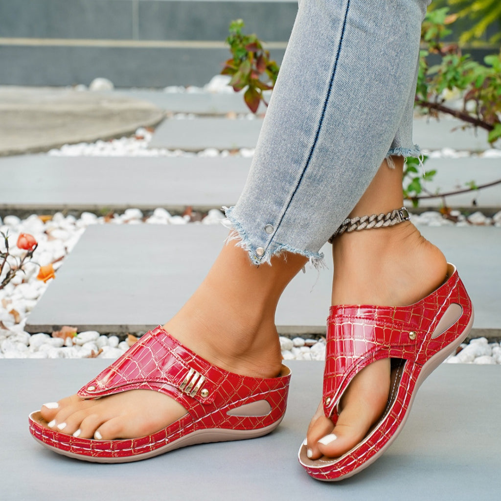 Women's faux leather wedge sandals with toe post and mid-heel, featuring a stylish design and comfortable fit.