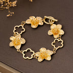 18K gold-plated flower bracelet with delicate floral charms, featuring a fine chain and elegant design.