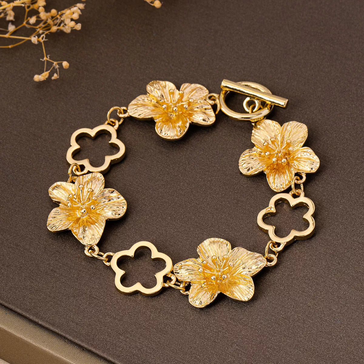 Gold-plated flower bracelet from Shopimist showcasing delicate floral design and shiny 18K gold finish on a white background.