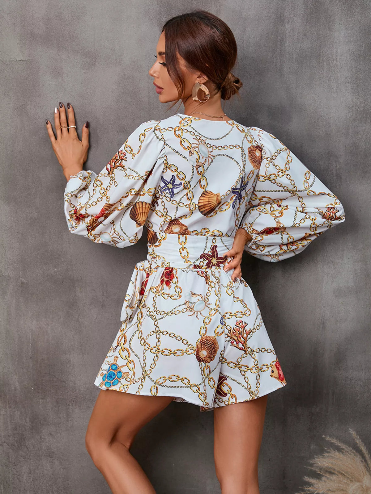 Printed long sleeve romper jumpsuit with cutout front by Plush Fashion Hub, featuring stylish design and comfortable fit.
