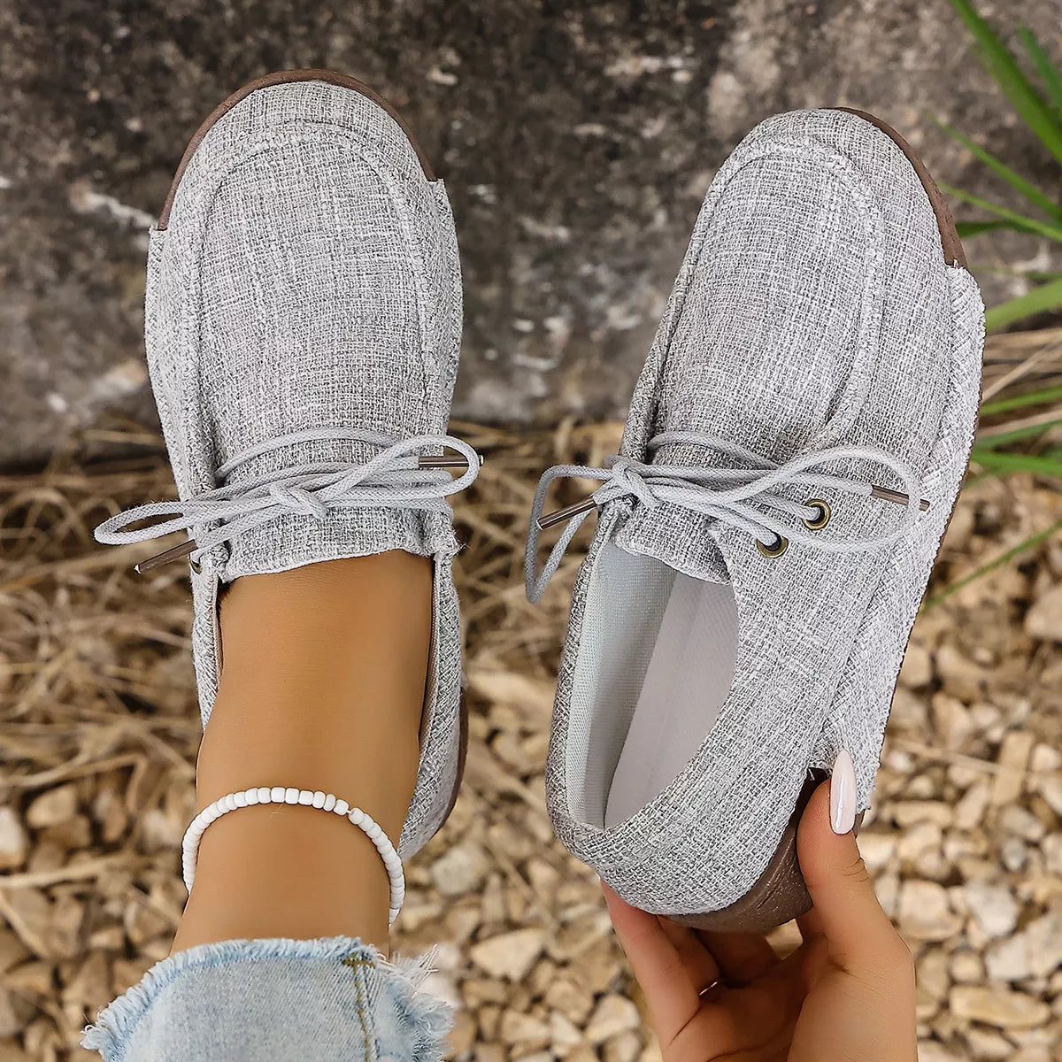 Round toe lace-up sneakers by Trendsi, featuring a stylish design with white laces and a sleek footwear silhouette.