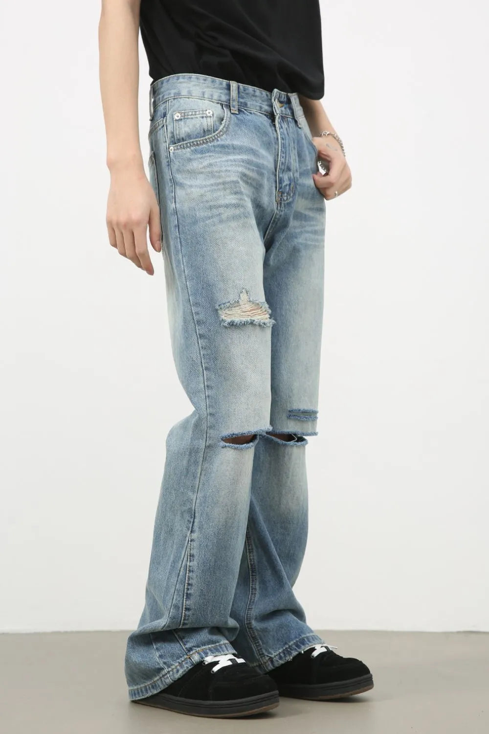Men's distressed denim jeans by Plush Fashion Shop, showing fit and rips, styled casually on a model.