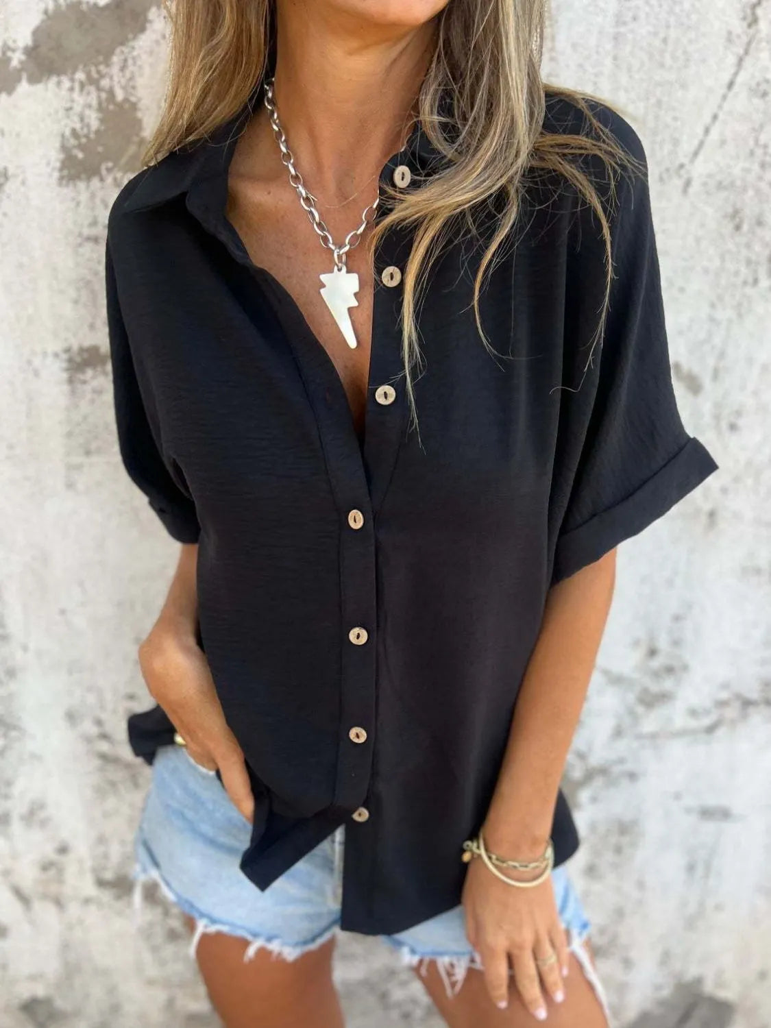 Women's collared half sleeve button-down blouse by Trendsi, featuring a sophisticated office-ready top with a classic design.