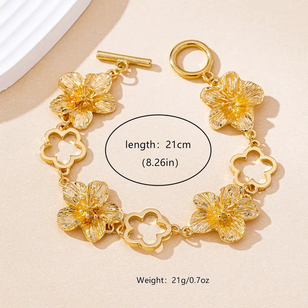 18K gold-plated flower bracelet featuring delicate floral charms, stylish jewelry piece with intricate design and shiny finish.