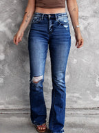 Distressed flare denim jeans from Plush Fashion Shop featuring ripped details and a retro fit, shown on a model.