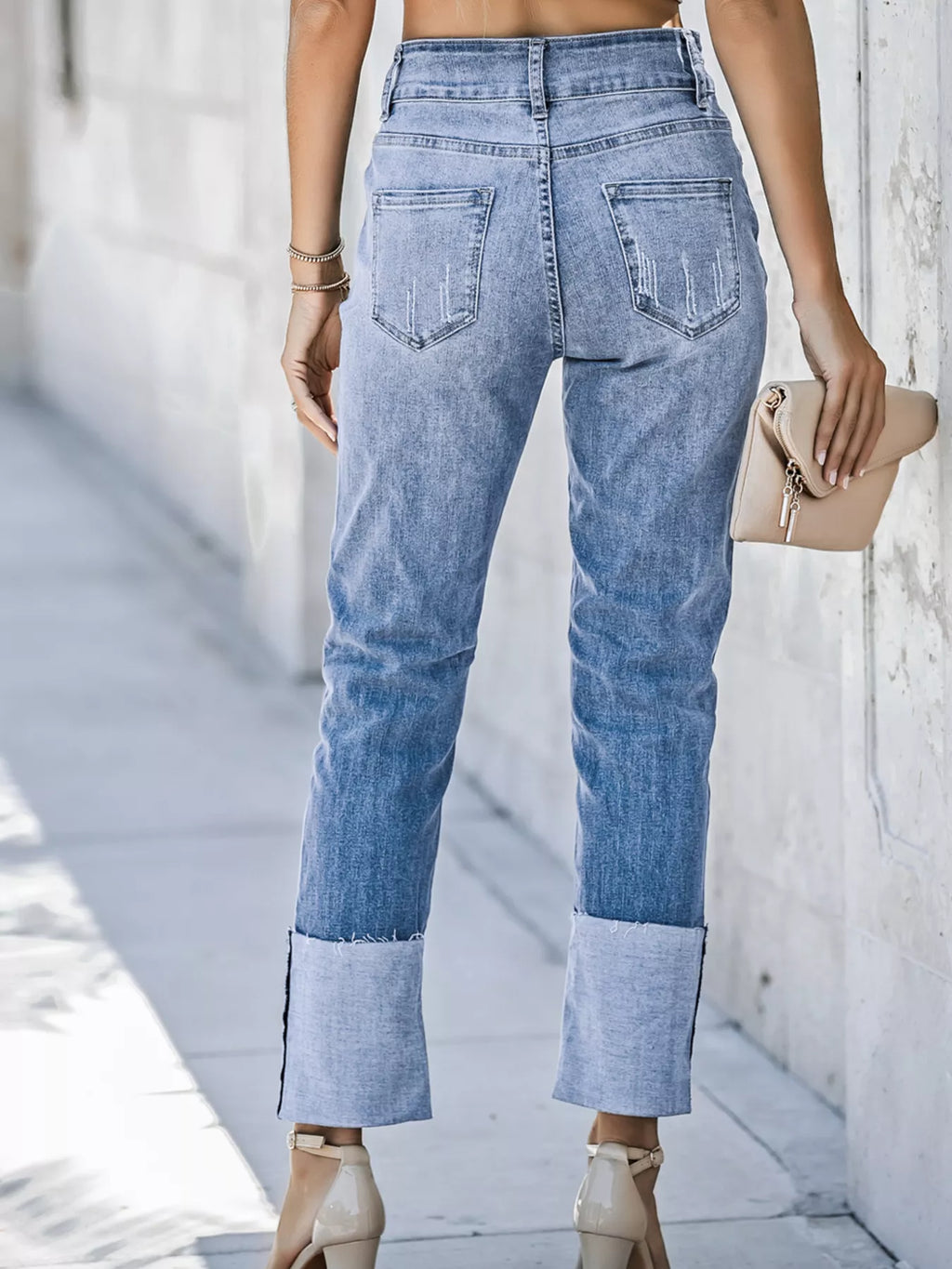High waist distressed straight leg jeans by Trendsi, showing a close-up of the light-wash denim with ripped details and classic fit.
