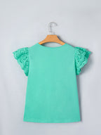 Ruffled eyelet lace cap sleeve top with cutout detail, stylish and feminine blouse from Trendsi, featuring delicate lace and ruffled accents.