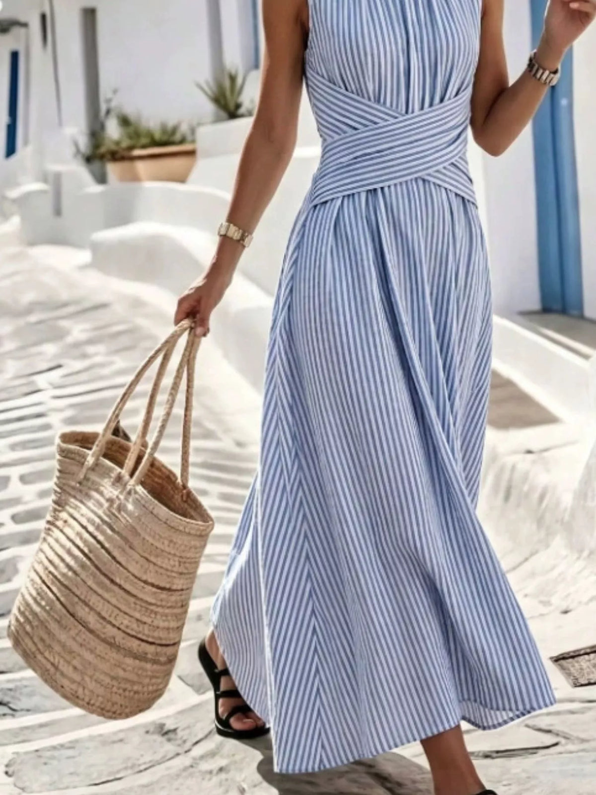 Plus size striped sleeveless maxi dress by Trendsi featuring a flowing full-length design and vibrant vertical stripes.