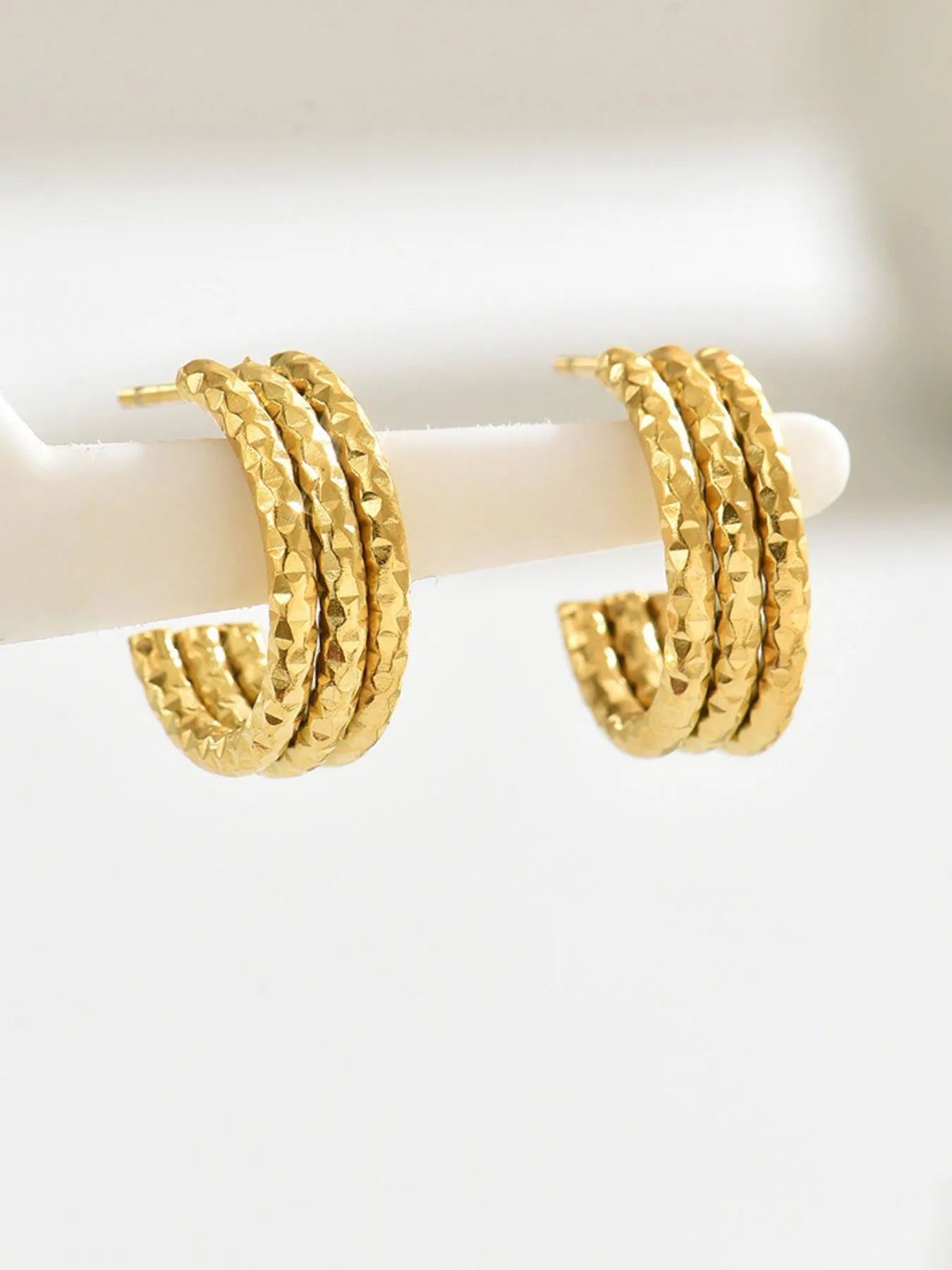 18K gold-plated textured triple band hoop earrings with a stylish, layered design and shiny finish.