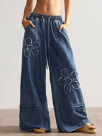 Wide leg jeans with floral appliques from Shopimist, showcasing detailed floral embroidery and relaxed fit style.