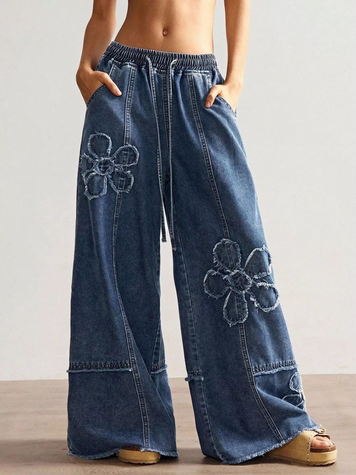 Wide leg jeans with floral appliques from Shopimist, showcasing detailed floral embroidery and relaxed fit style.