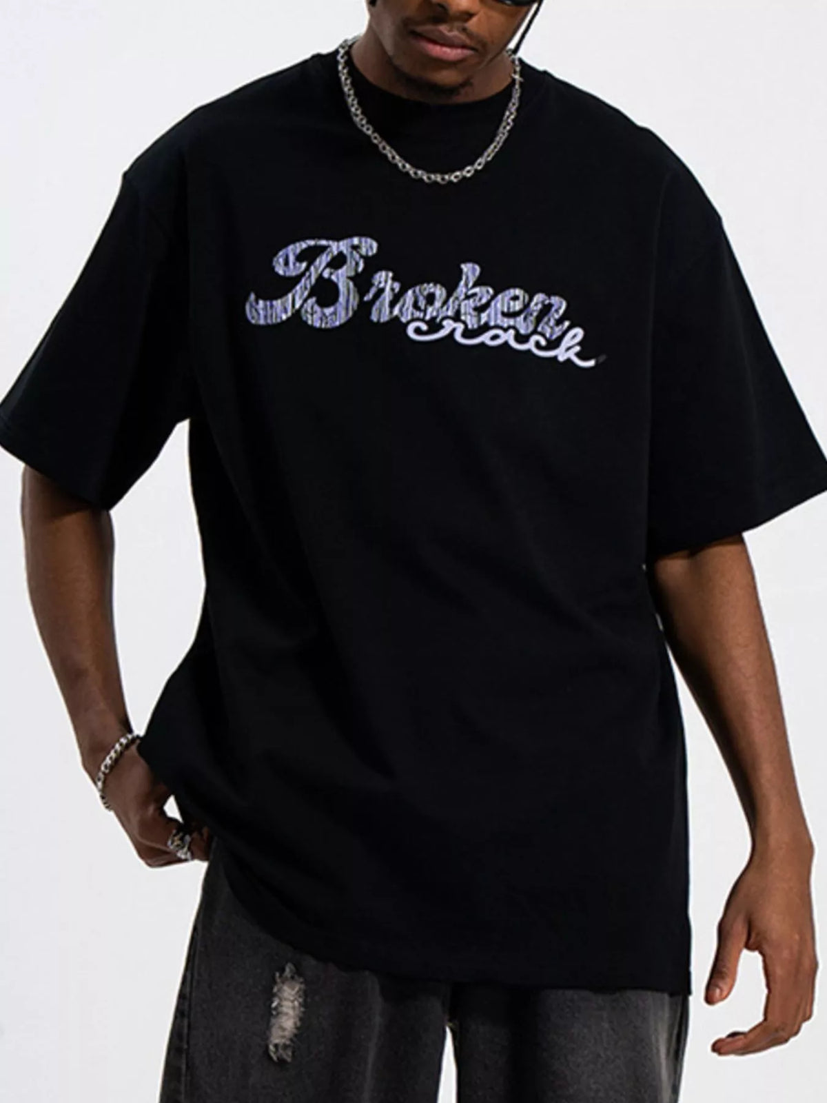 Men's oversized graphic round neck T-shirt by Trendsi, featuring bold print on soft cotton fabric.