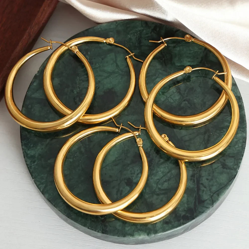 18K gold-plated hoop earrings by Shopimist, showcasing smooth, circular design with a shiny finish on a white background.