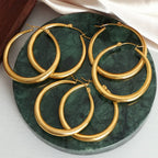 18K gold-plated hoop earrings by Shopimist, showcasing smooth, circular design with a shiny finish on a white background.