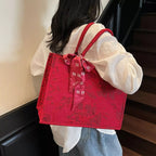 Floral embossed tote handbag with scarf accent by Shopimist, featuring textured floral design and stylish fabric scarf detail.