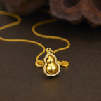 18K gold-plated gourd pendant necklace with intricate detailing, hanging from a delicate chain, showcased against a neutral background.