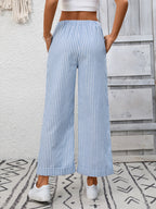 Women's striped wide leg pants with drawstring waist and pockets, branded by Trendsi, shown hanging with a relaxed fit.