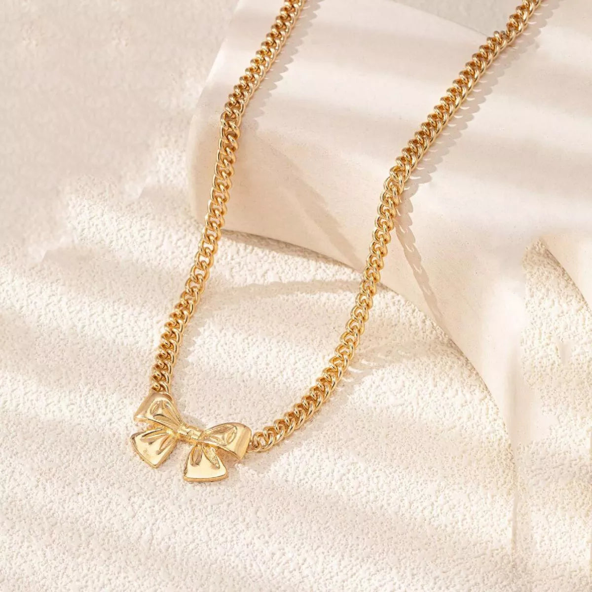18K gold-plated bowknot chain necklace by Simply Love, close-up of the elegant jewelry with a delicate bow design