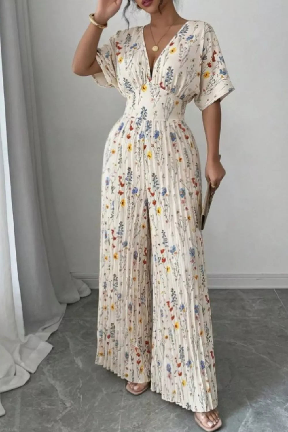 Floral print wide-leg pleated jumpsuit from Trendsi, featuring a flowing silhouette and vibrant floral design.