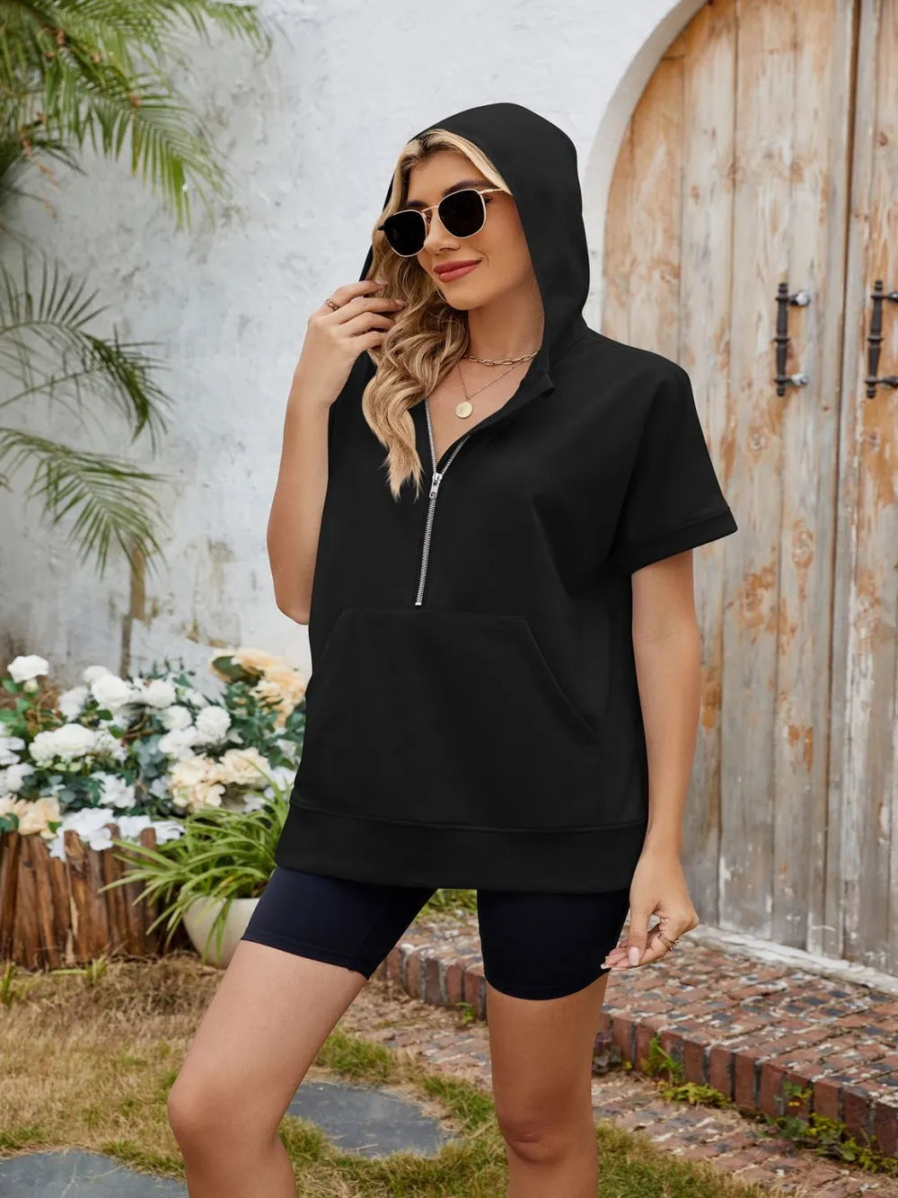 Trendsi half zip short sleeve hooded top, casual athletic style, with a front zipper and hood, worn by a model.