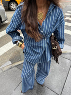 Women's striped button-up shirt and wide-leg pants two-piece set by Trendsi, featuring stylish, coordinated clothing on a model.