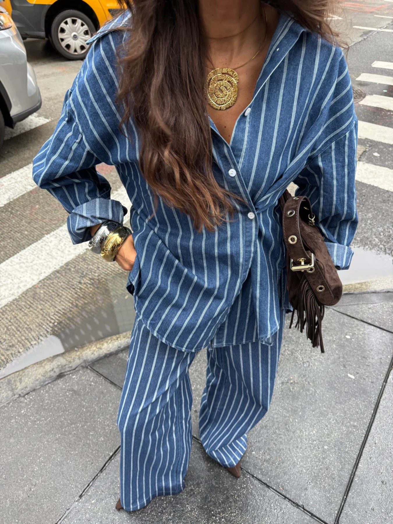 Women's striped button-up shirt and wide-leg pants two-piece set by Trendsi, featuring stylish, coordinated clothing on a model.