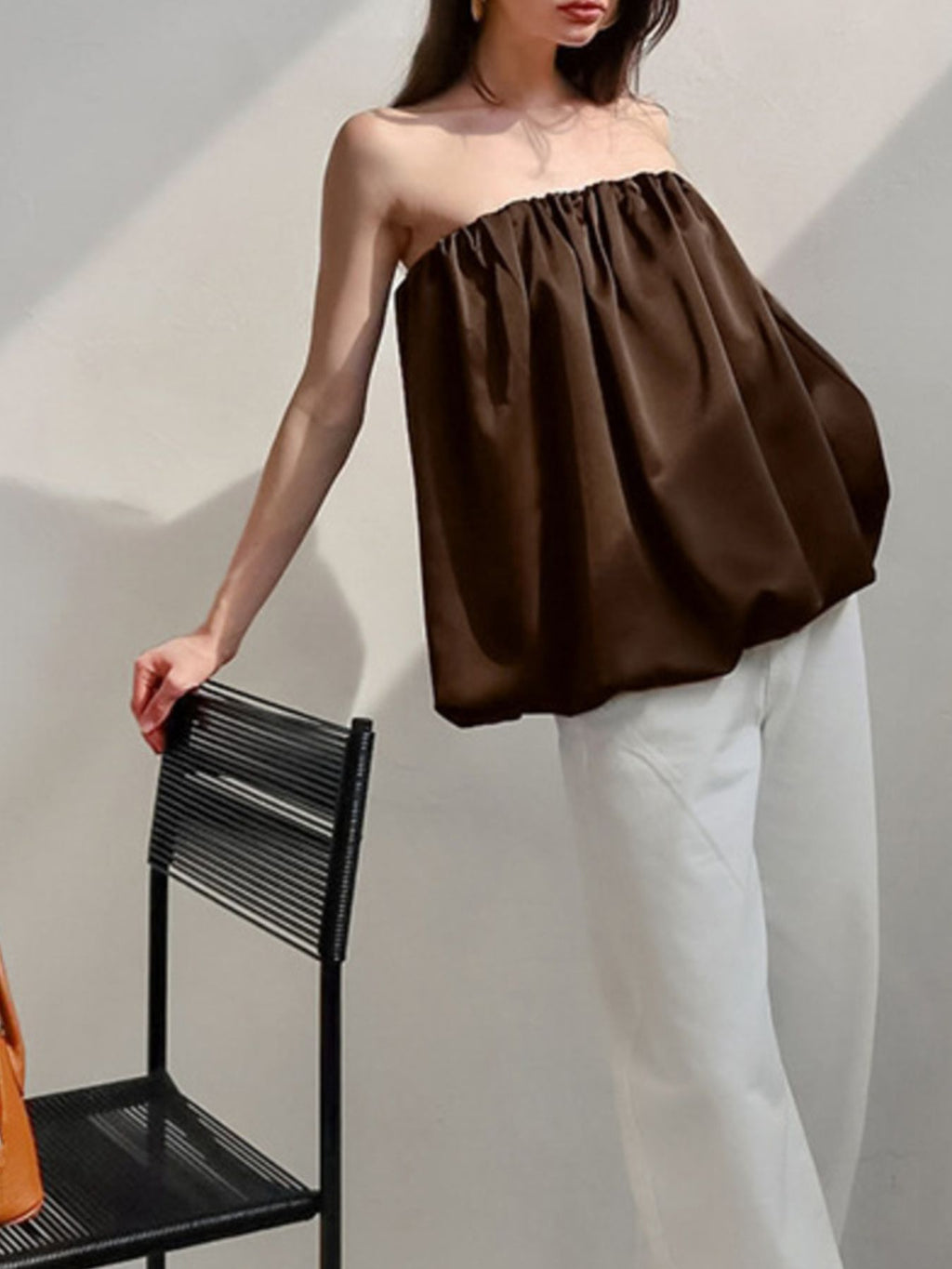Women's strapless bubble hem tube top from Plush Fashion Hub, sleek minimalist crop top in black fabric, displayed on a white background.