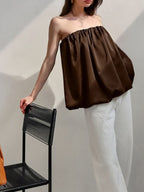 Women's strapless bubble hem tube top from Plush Fashion Hub, sleek minimalist crop top in black fabric, displayed on a white background.