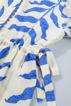Leafy botanical print maxi dress with side tie and button-down front from Shopimist, featuring a flowing, floral design.