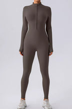 Trendsi half zip mock neck active jumpsuit in black, featuring long sleeves and fitted design for workout or athleisure wear.