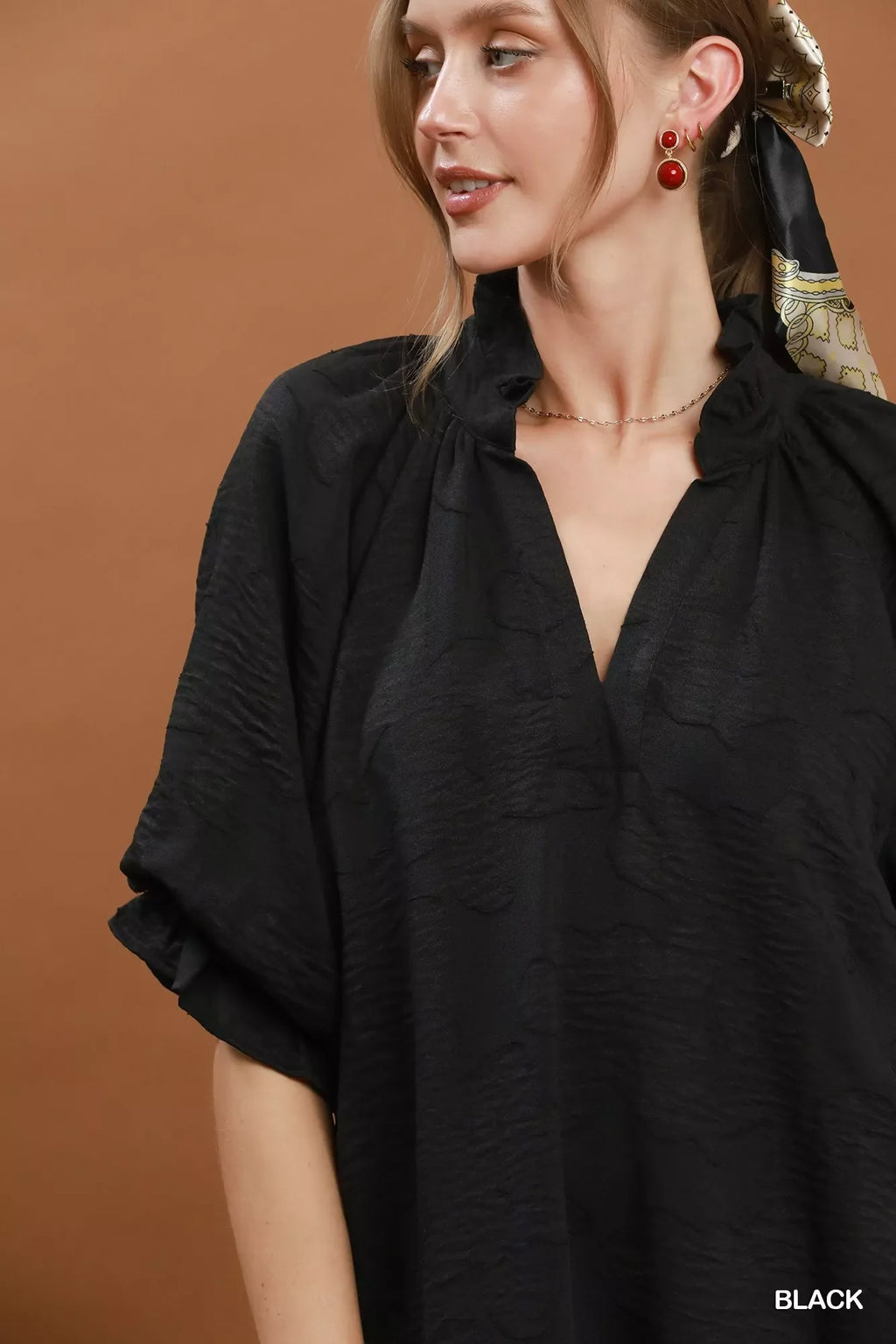 Umgee floral textured jacquard v-neck dress with a fitted waist and flowing skirt, displayed on a hanger.