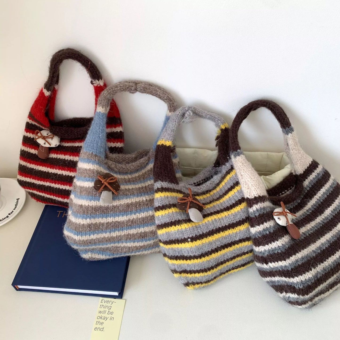 Knitted striped handbag from Plush Fashion Hub featuring colorful woven design and sturdy handles.