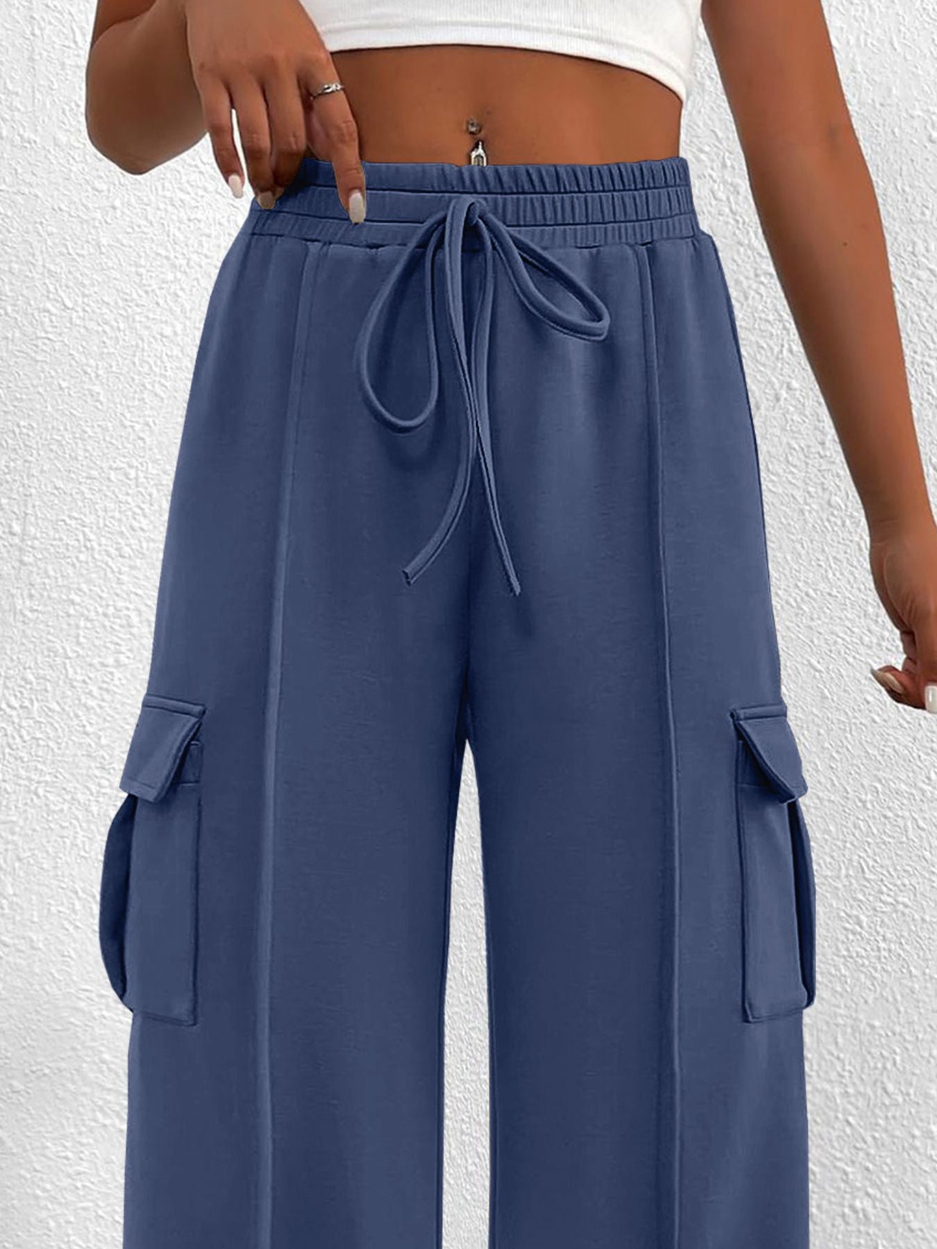 Women's high-waisted casual cargo pants with drawstring, lightweight utility style, shown in neutral fabric with pockets.