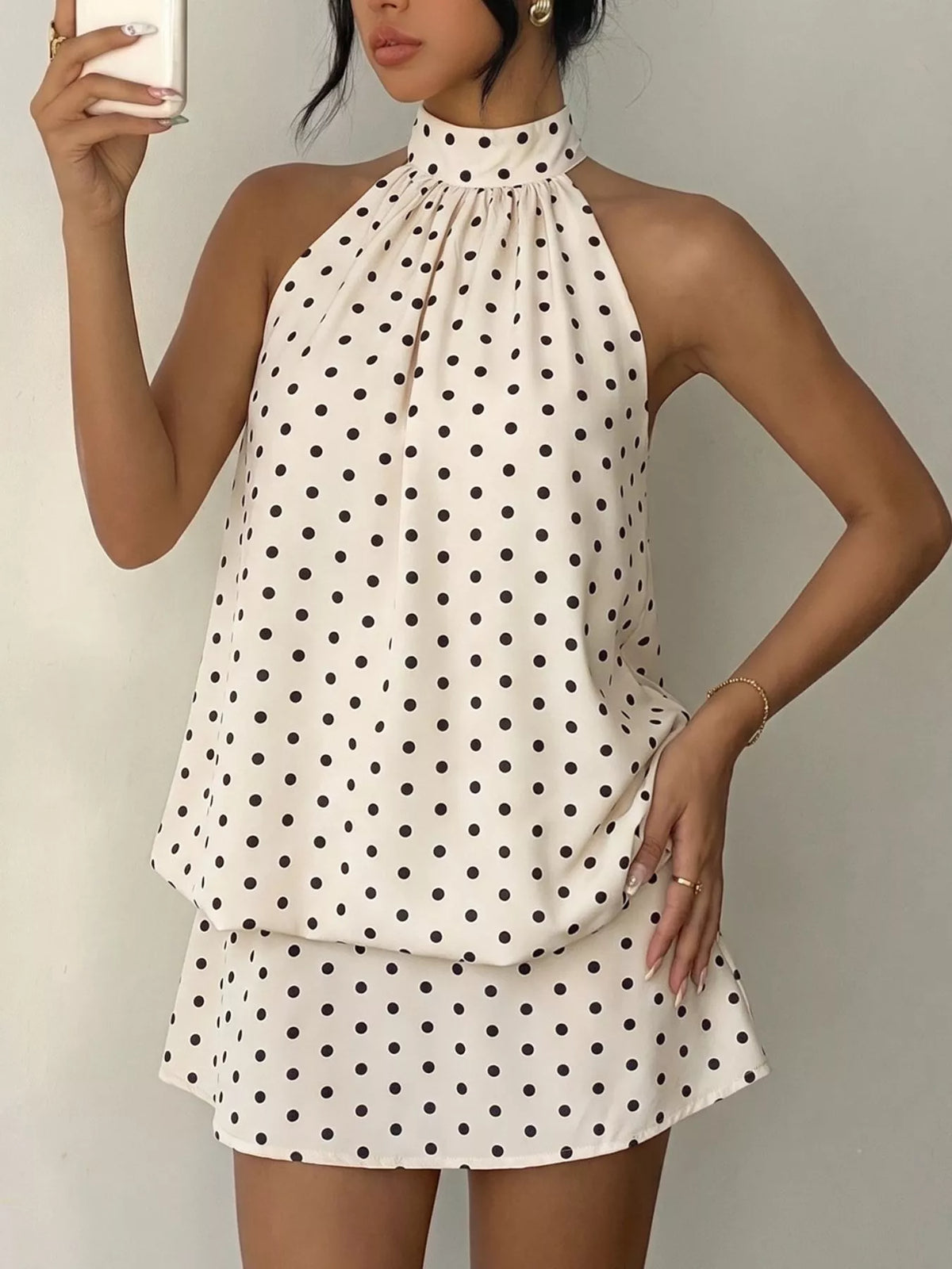 Polka dot halter neck mini dress by Plush Fashion Hub featuring a fitted silhouette and stylish polka dot pattern.
