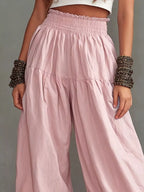 Plus size wide-leg pants with smocked waist and ruffle hem from Trendsi, featuring a relaxed fit and flowy fabric.