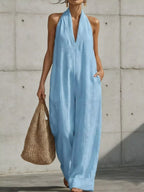 Plus size full-length halter neck jumpsuit with wide-leg design by Trendsi, shown in a stylish, comfortable look.