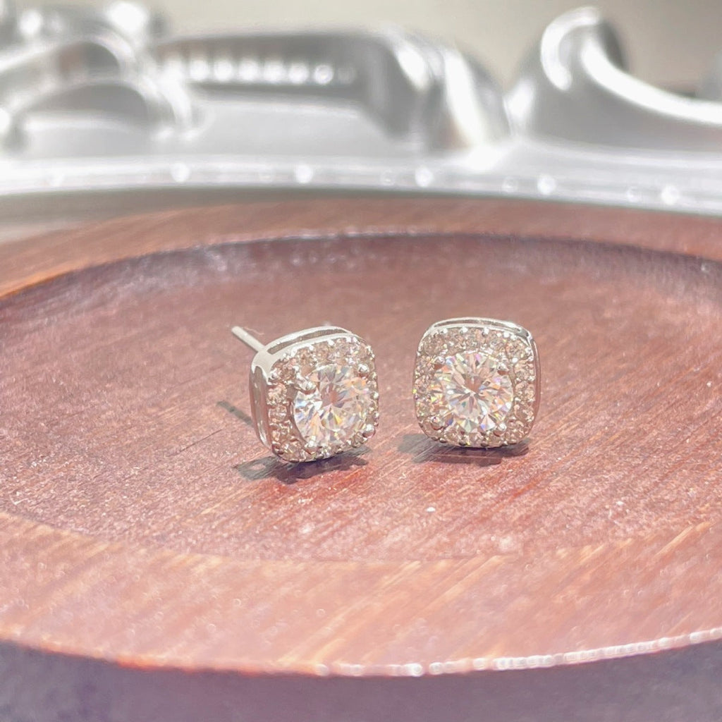 Sterling silver stud earrings with 1 carat moissanite gemstones, featuring a simple and elegant design.