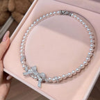Pearl necklace with a bow pendant, elegant jewelry piece featuring white pearls and a delicate bow charm.