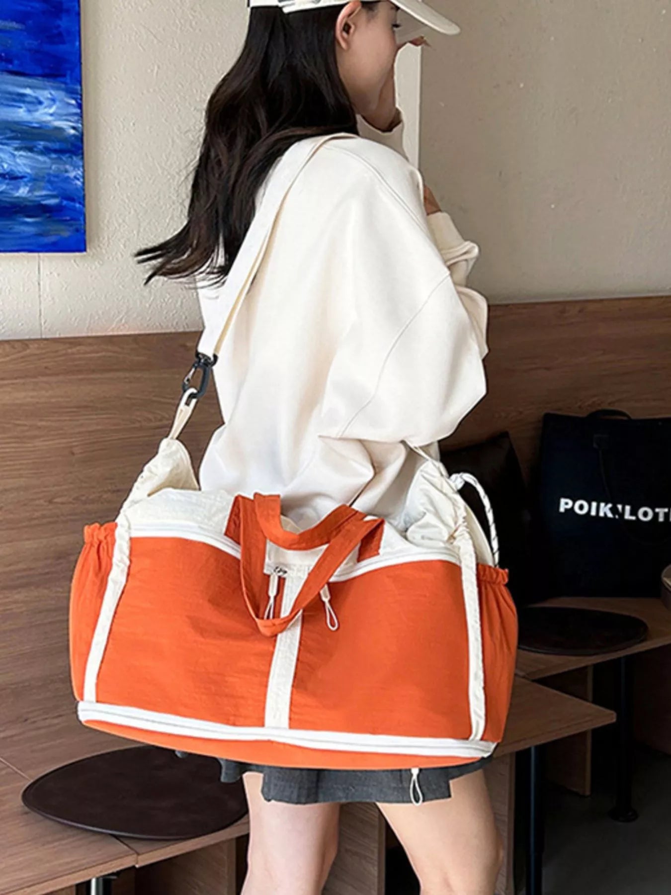 Color-block travel bag by Shopimist featuring vibrant color panels, durable handles, and spacious main compartment for travel essentials.