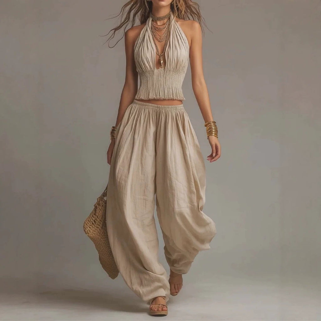 Women's sleeveless backless halter top and wide-leg pants set by FitiqueFit, featuring a stylish halter neckline and flowing pant legs.