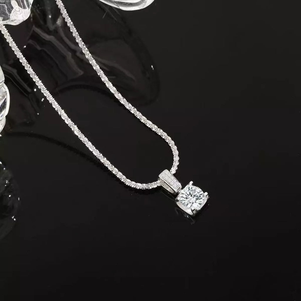 Sterling silver moissanite necklace with 1 carat center stone, showcasing elegant jewelry design and sparkling gemstone detail.