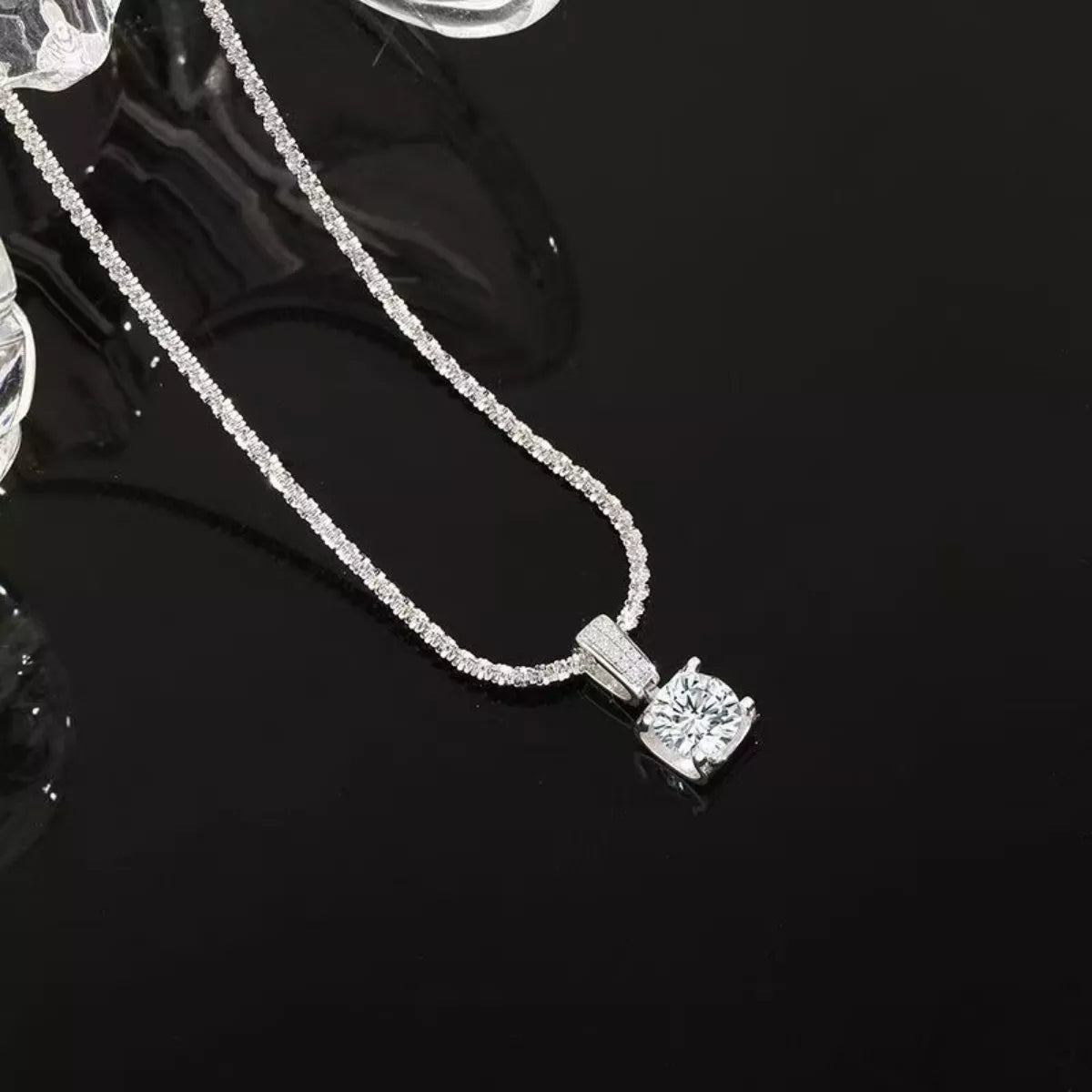 Sterling silver moissanite necklace with 1 carat center stone, showcasing elegant jewelry design and sparkling gemstone detail.