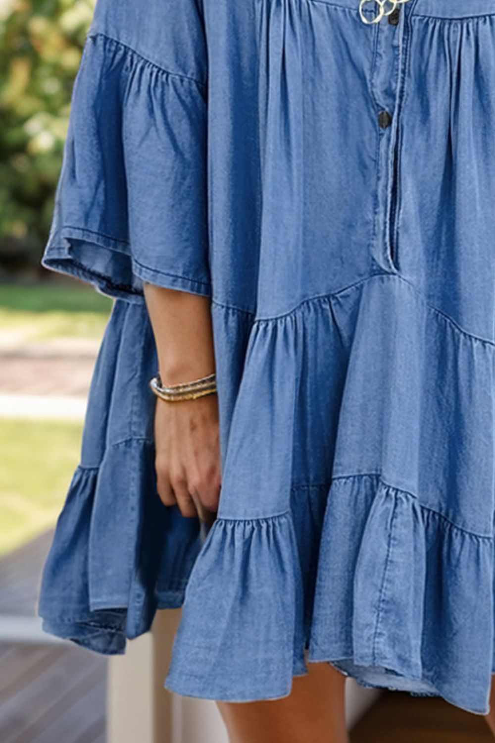 VYSN Notched Flare Sleeve Denim Dress displayed on a hanger with a close-up of the stylish sleeve details.